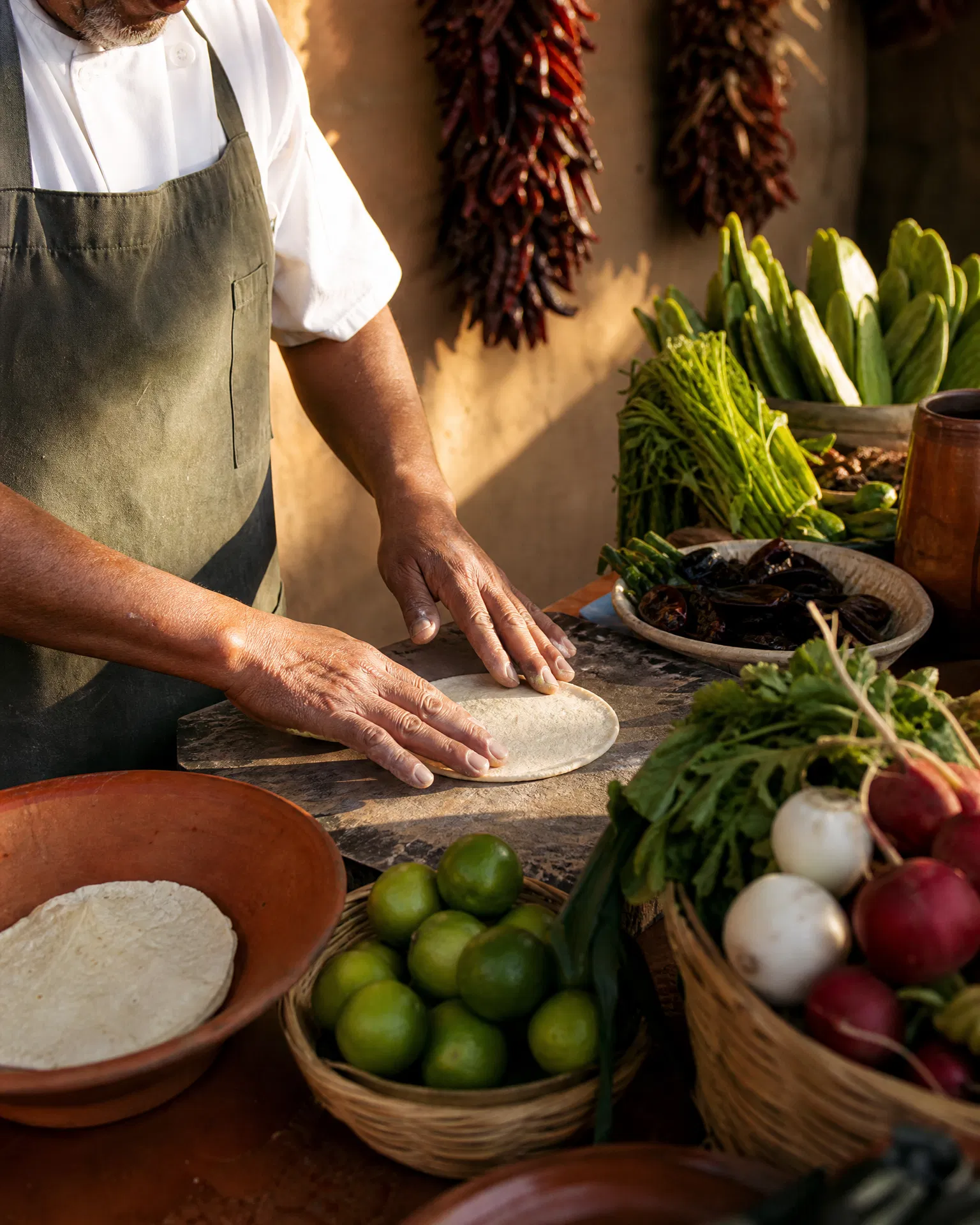 A chef pressing fresh masa tortillas by hand